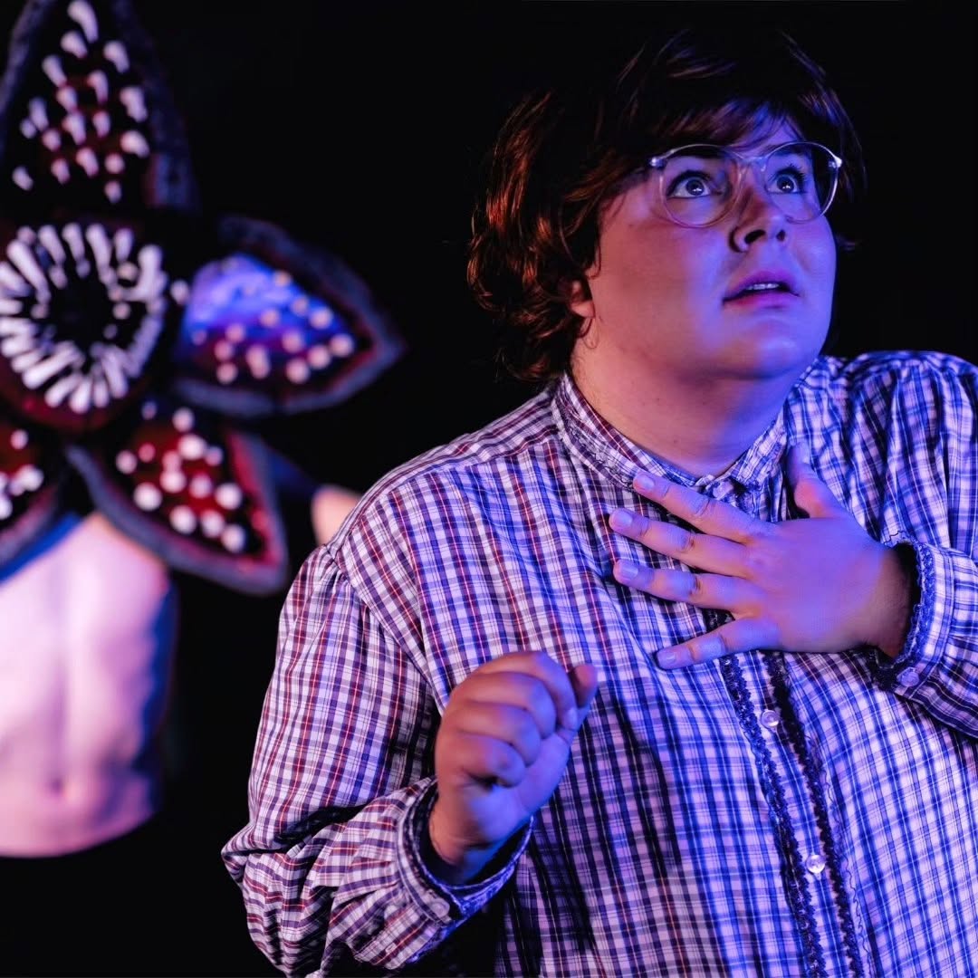 A performer lit by purple stage light
